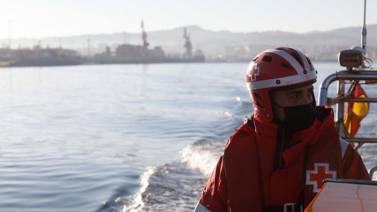 Sobre estas líneas, Alberto Mahia en laborales de mantenimiento. Arriba, los voluntarios con la costa de la playa de San Juan al fondo. | M. Villamuza