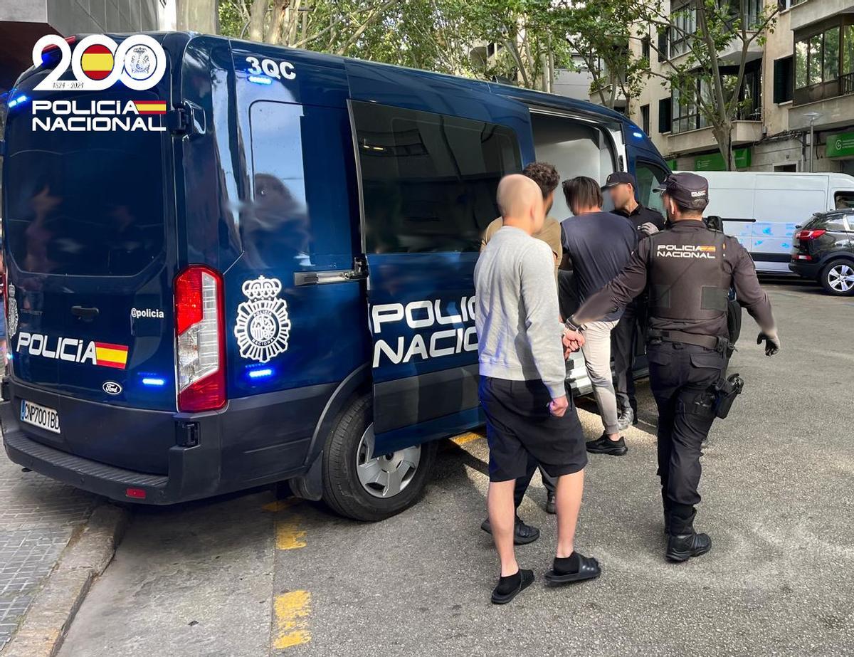 Agentes de la Policía Nacional llevan detenidos a los presuntos extorsionadores suecos.