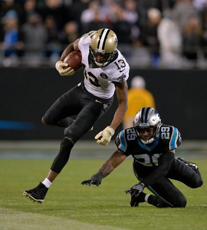 Michael Thomas # 13 de los New Orleans Saints corre el balón contra Mike Adams # 29 de los Carolina Panthers, en el Bank of America Stadium, en Charlotte, Carolina del Norte.