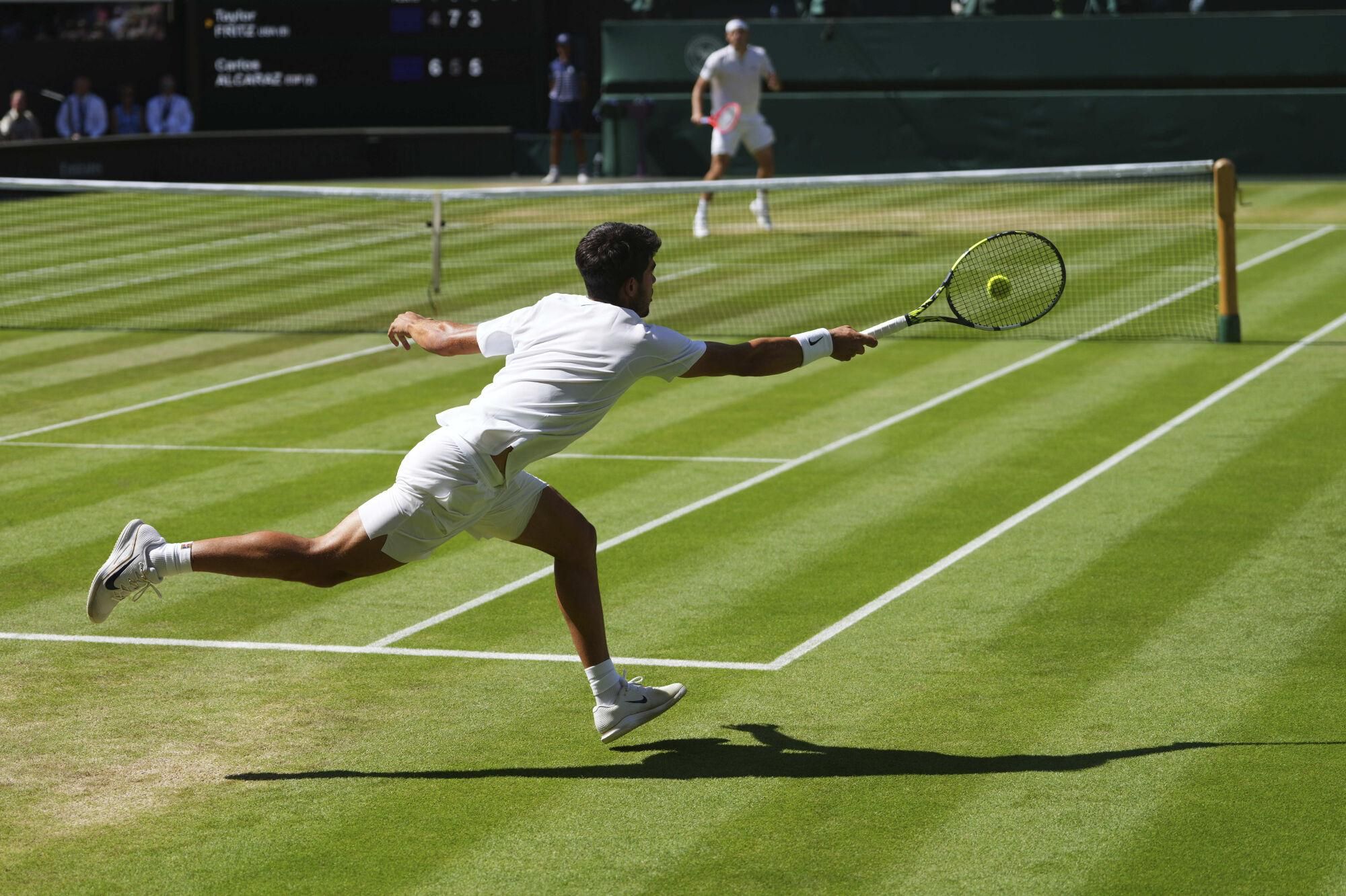 Carlos Alcaraz of Spain returns the ball to Taylor Fritz of the U.S. during the men's semifinal singles match at the Wimbledon Tennis Championships in London, Friday, July 11, 2025.(AP Photo/Kirsty Wigglesworth). EDITORIAL USE ONLY/ONLY ITALY AND SPAIN