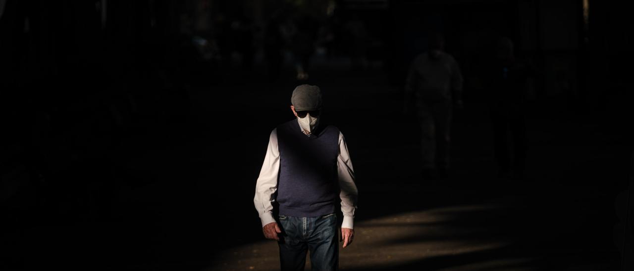 Un  hombre pasea por Santa Cruz con su mascarilla.