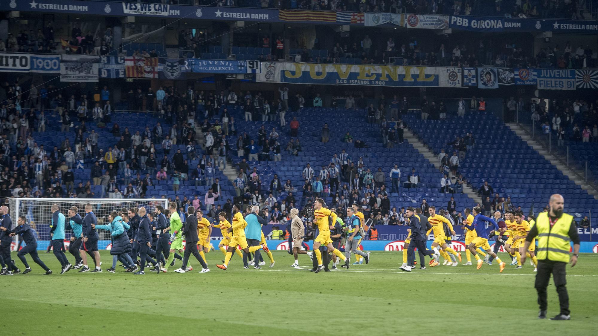 Los jugadores del Barça corren hacia los vestuarios al ver la invasión de campo de seguidores blanquiazules tras su celebración del título de liga en el RCDE Stadium