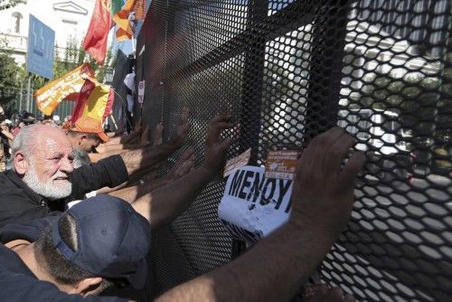 Line of protesters push against a steel protective fence at a protest march by Greece's Communist party in central Athens during a 24-hour labour strike