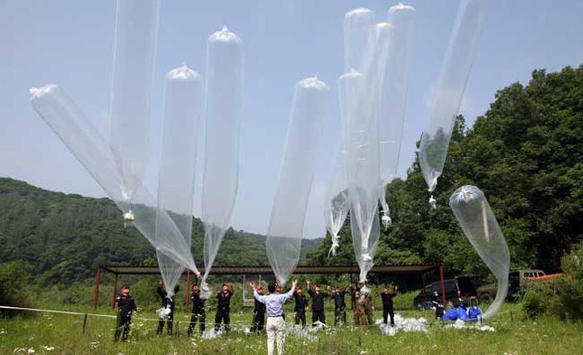 Manifestants conservadors deixen anar globus que porten fullets anti-Corea del Nord en un camp a prop de la zona desmilitaritzada que separa les dues Corees a Yeoncheon, uns 62 km al nord de Seül, per commemorar el pròxim 61è aniversari de l’esclat de la guerra de Corea.