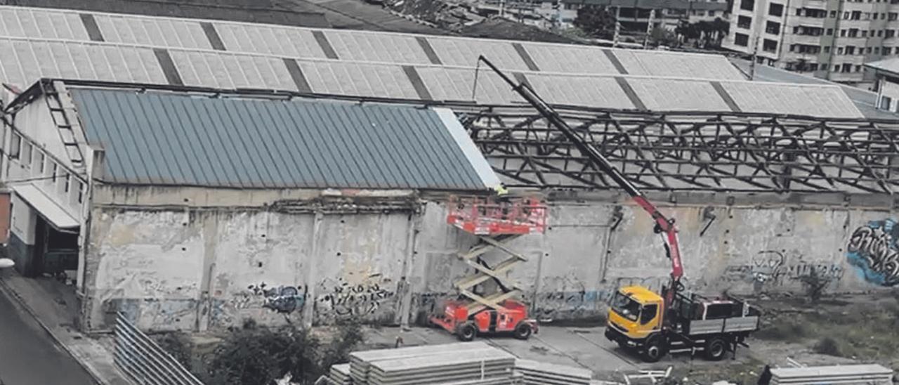 Trabajadores cambian el techo de la nave que va a ocupar el nuevo centro cultural de Ciudad Naranco.