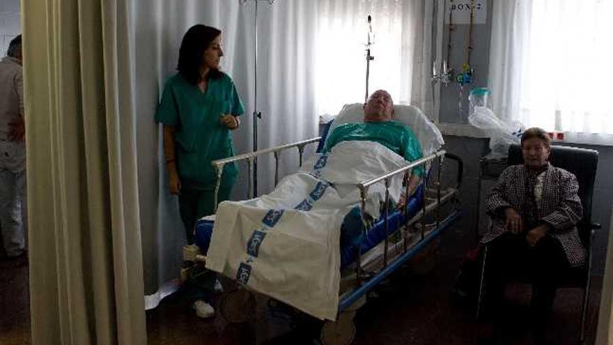 Una de las nuevas salas de boxes de Urgencias del hospital benaventano, con una trabajadora sanitaria, un enfermo y su familiar.