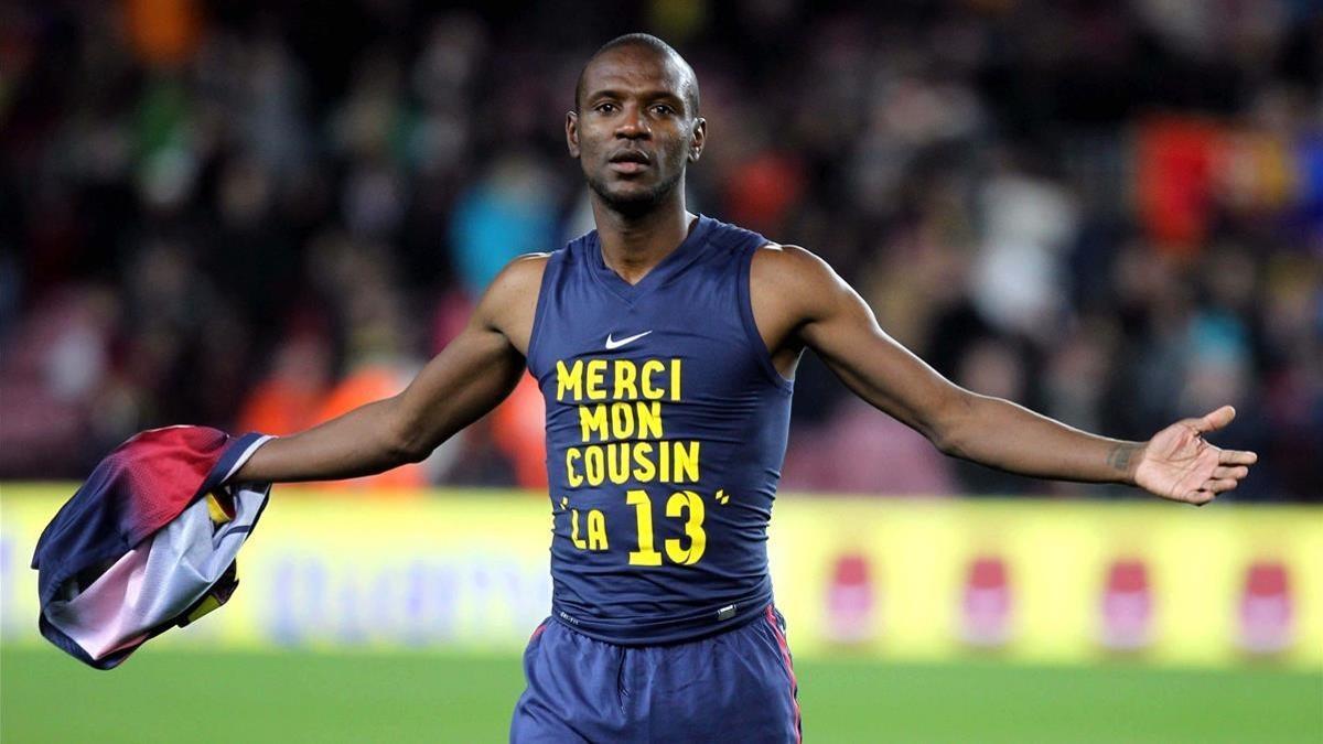 El defensa francés del FC Barcelona Eric Abidal muestra una camiseta de agradecimiento a su primo, donante en su trasplante.