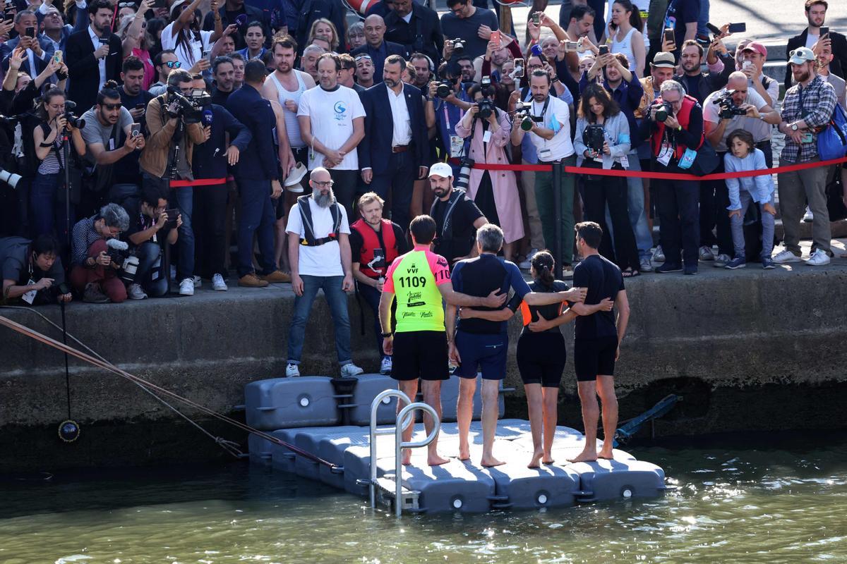 Paris Mayor Anne Hidalgo (2ndR, back) and the President of the Paris 2024 Olympics and Paralympics Organising Committee (Cojo) Tony Estanguet (R, back) pose for photographers and journalists after swimming in the Seine River, in Paris on July 17, 2024, to demonstrate that the river is clean enough to host the outdoor swimming events at the Paris Olympics later this month. Despite an investment of 1.4 billion euros ($1.5 billion) to prevent sewage leaks into the waterway, the Seine has been causing suspense in the run-up to the opening of the Paris Games on July 26 after repeatedly failing water quality tests. But since the beginning of July, with heavy rains finally giving way to sunnier weather, samples have shown the river to be ready for the open-water swimming and triathlon -- and for 65-year-old Hidalgo. (Photo by EMMANUEL DUNAND / AFP)