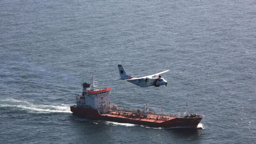 Un anvión de Salvamento sobrevuela un buque. | // SASEMAR