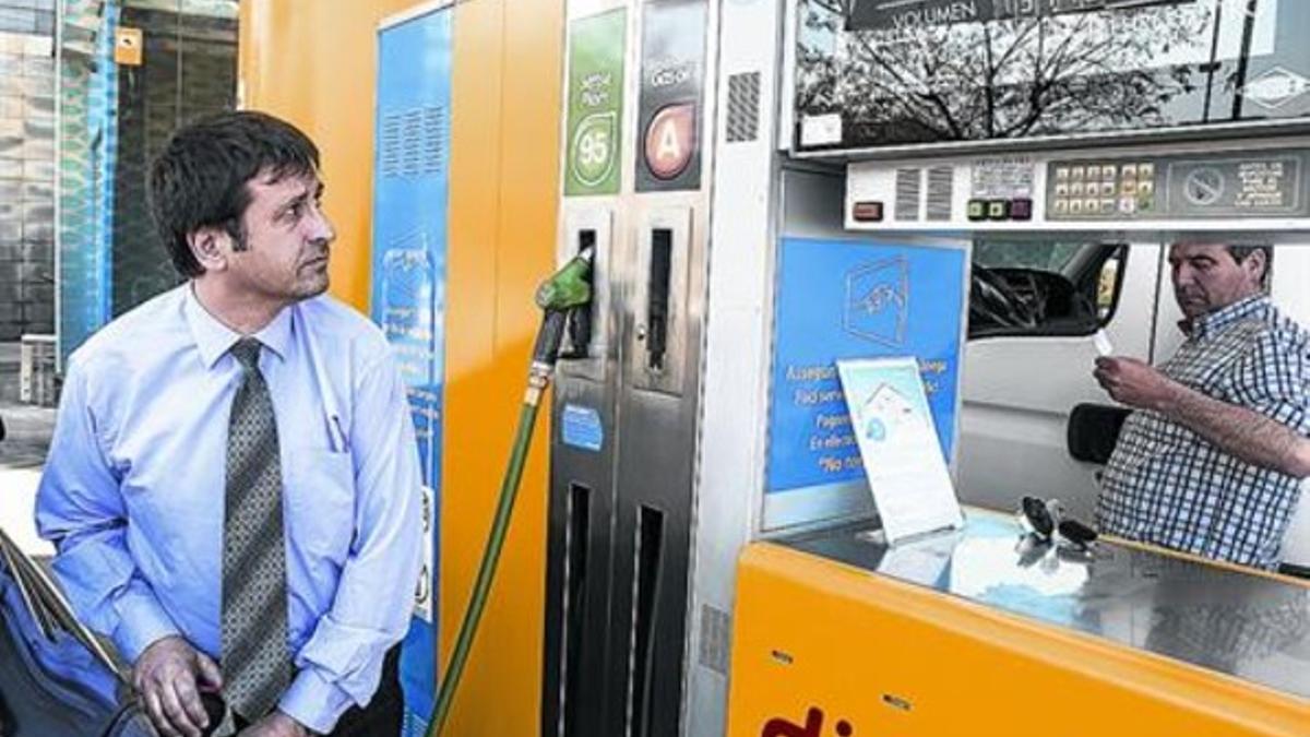 Un usario carga el coche con gaslina, ayer en Barcelona.