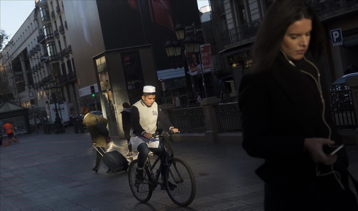 Ciclista circulando por el centro de La Rambla de Barcelona, algo prohibido desde el 1 de enero.