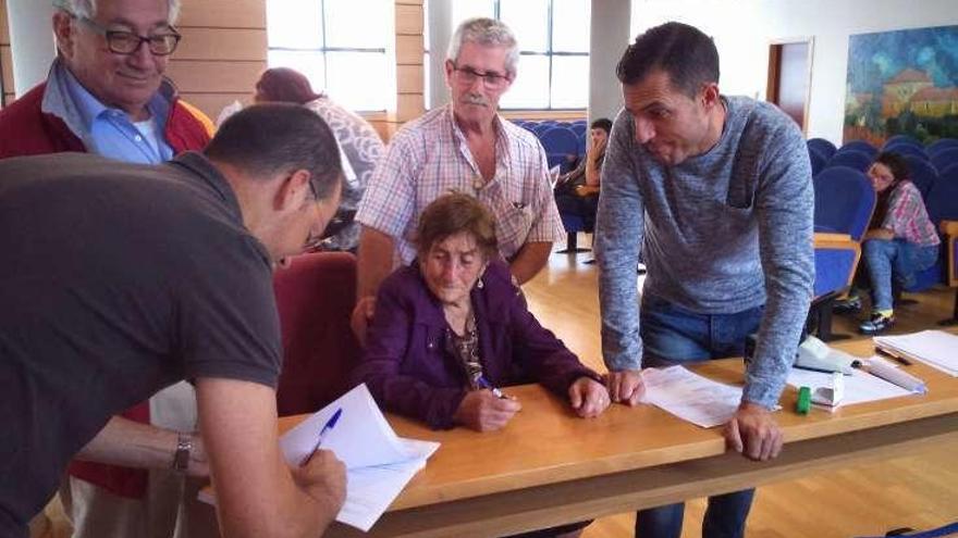 Vecinos firmando actas de expropiación de fincas en Moaña. // S.Á.