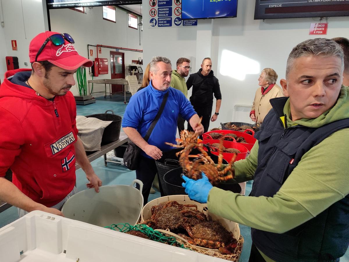 El comprador José Luis Fontán (dcha.), en la subasta en Cangas.