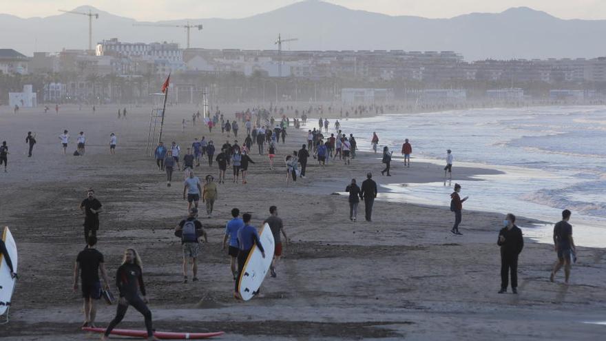 Personas pasean por la playa de la Malva-rosa.