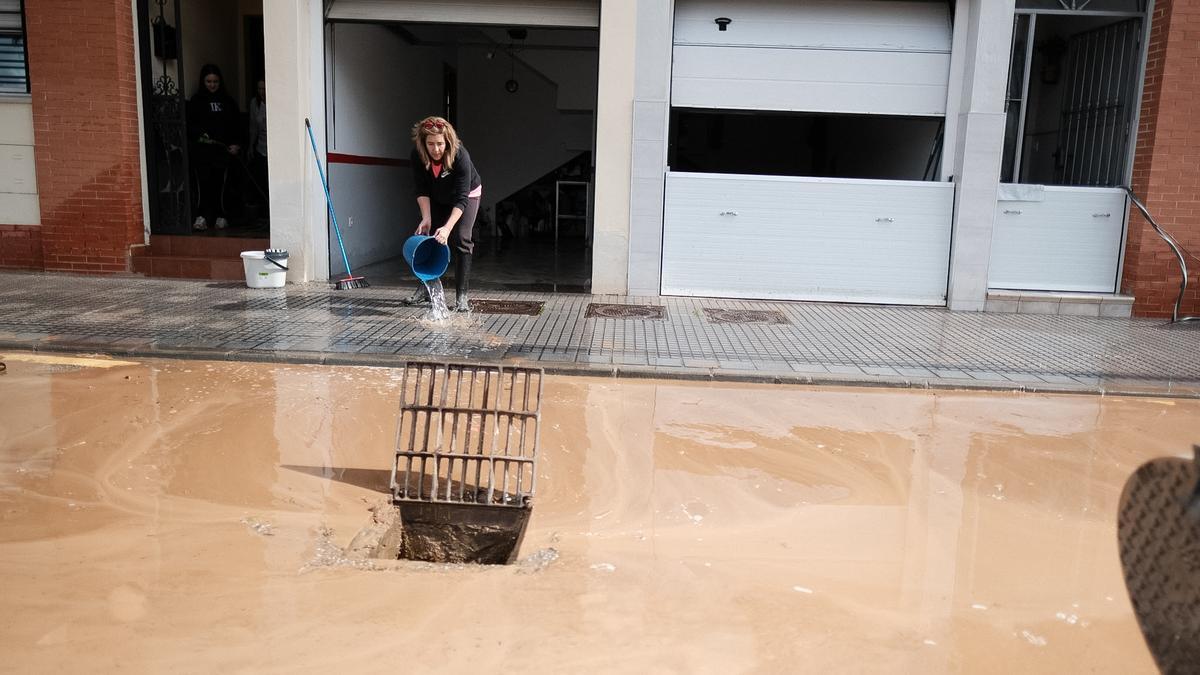 Una vecina achica agua este martes en Campanillas, tras haberse anegado la barriada