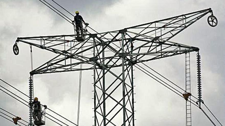 Dos trabajadores en el tendido eléctrico.