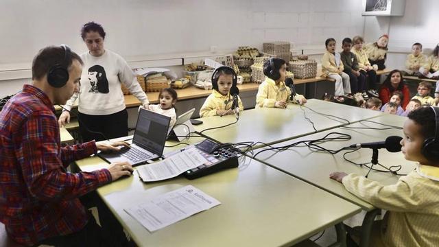 Escolinos del Santa Olaya a puntu d’entamar otra clas de radio. | MARCOS LEÓN
