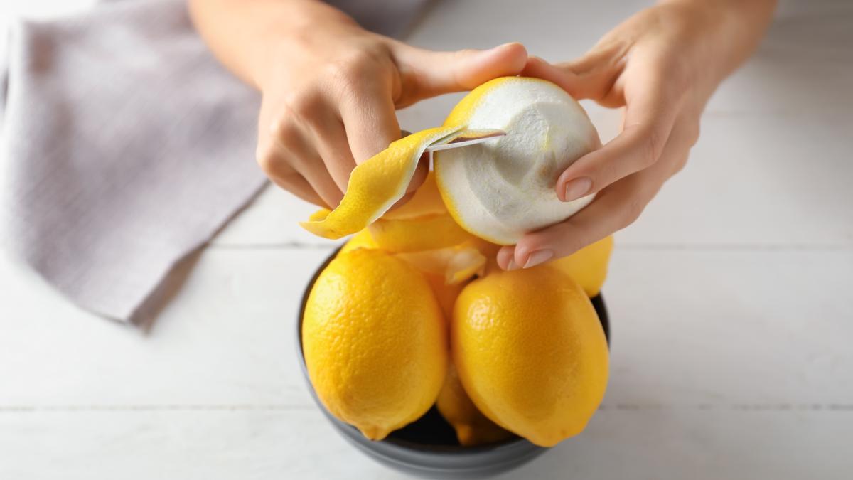 Mujer pelando un limón