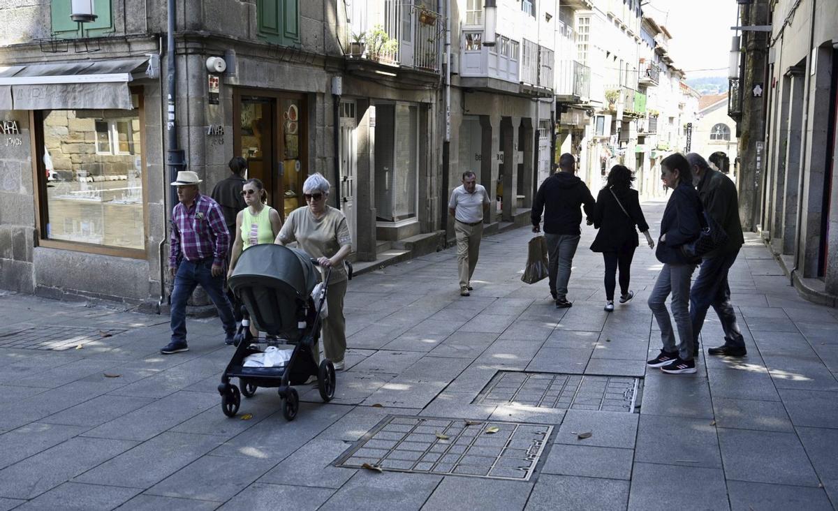 Gente caminando por el cruce entre las calles César Boente y Sarmiento, en la zona monumental de Pontevedra.