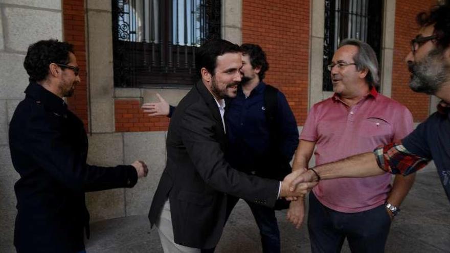 Garzón saluda a Viñas en presencia de Guarido.