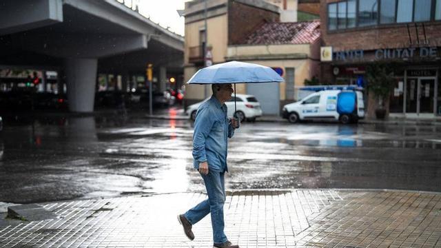 Persona amb paraigua sota la pluja a la ciutat de Badalona (Barcelona).