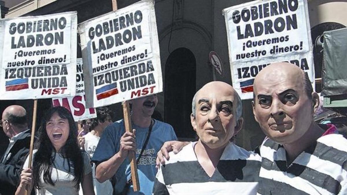 Manifestantes izquierdistas con caretas del presidente De la Rúa y del ministro de Economía Domingo Cavallo (derecha), el 6 de diciembre del 2001.