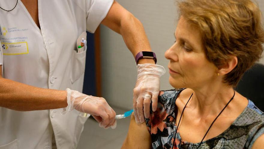 Una mujer se vacuna de la gripe en su centro de salud.