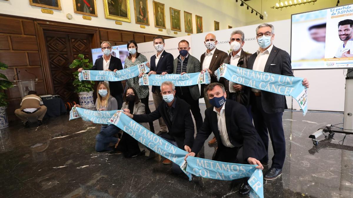 Los representantes de las diferentes instituciones posan con la bufanda del encuentro en el acto de presentación del evento.