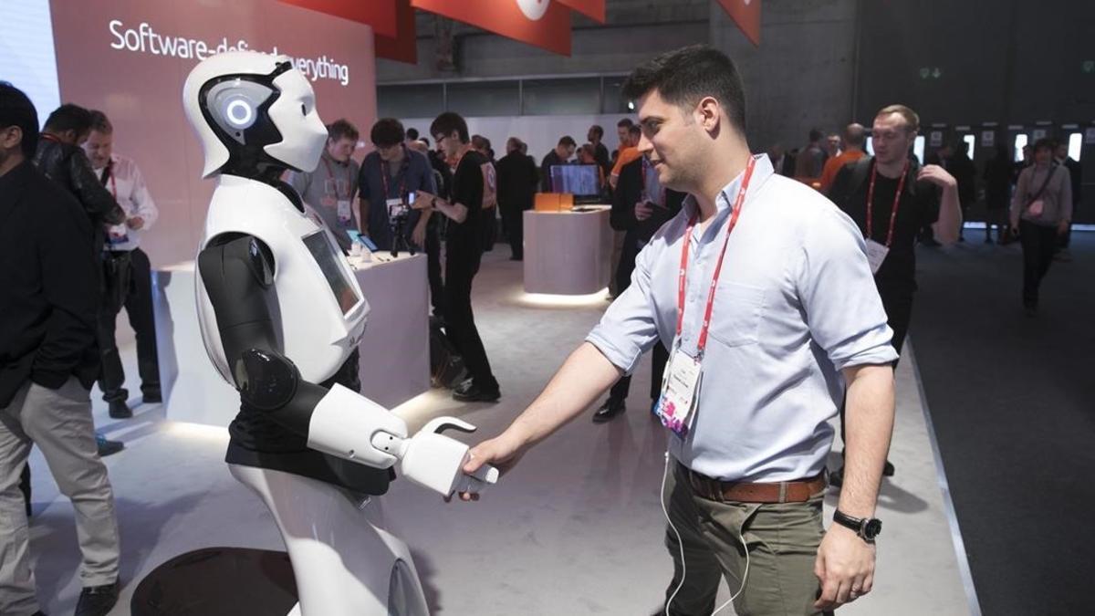 Un asistente saluda a un robot en el último Mobile World Congress.