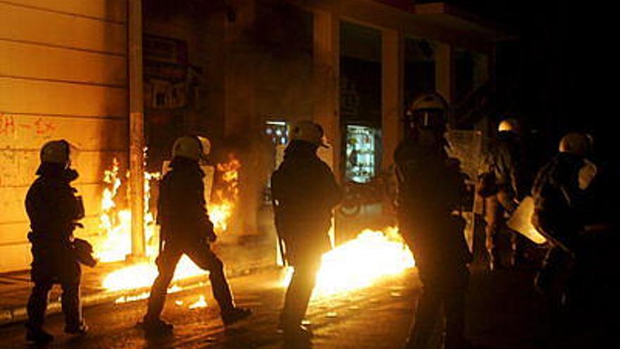 Miembros de la policía antimotines son atacados durante un choque con manifestantes , en el distrito de Exarheia, en el centro de Atenas (Grecia). Cientos de personas lanzaron bombas contra bancos, oficinas del Ministerio de Desarrollo y negocios, en el marco del octavo día de protestas tras la muerte por parte de la policía del joven de 15 años de edad Alexis Grigoropoulos.