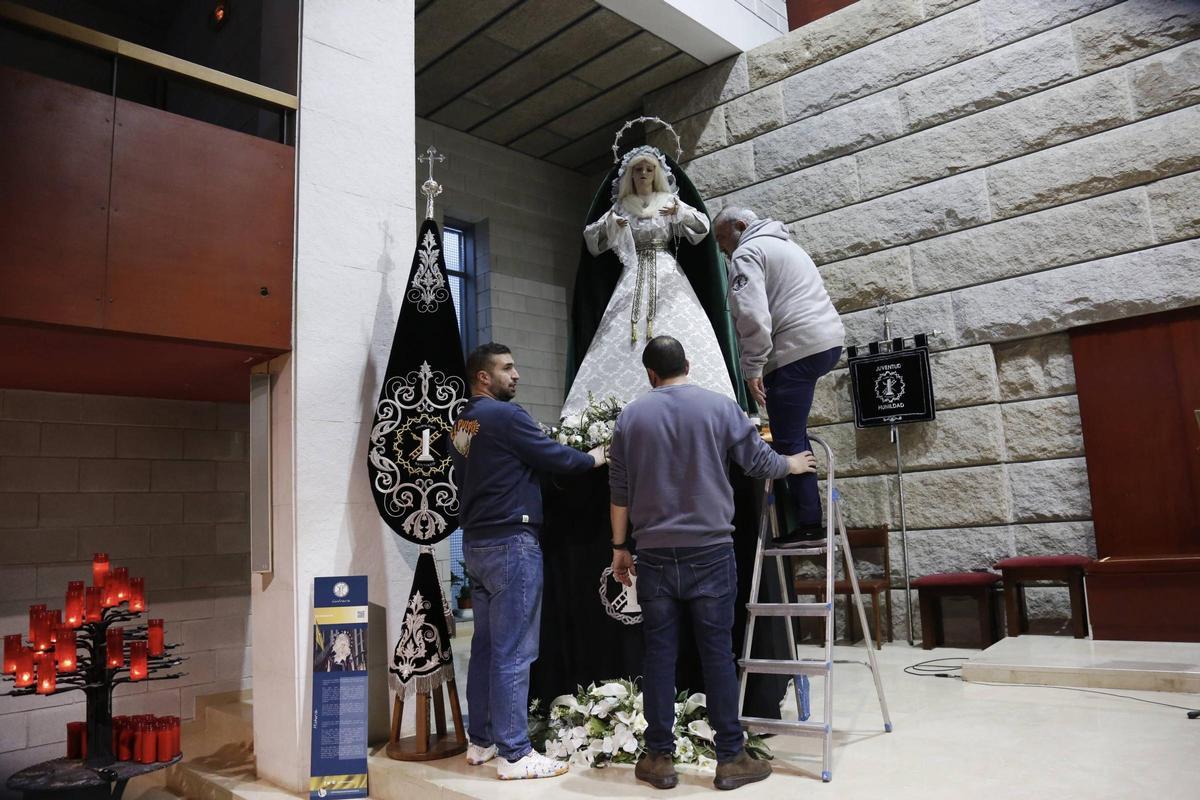 Tres cofrades de la Humildad realizan preparativos previos en la imagen en la iglesia parroquial de Vite.