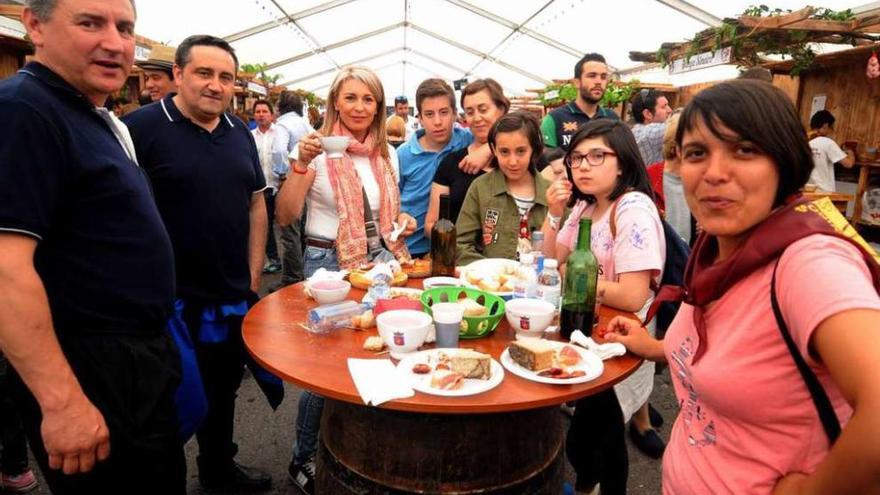 Un grupo de comensales comen y toman vino tinto dentro de la carpa oficial. // Iñaki Abella