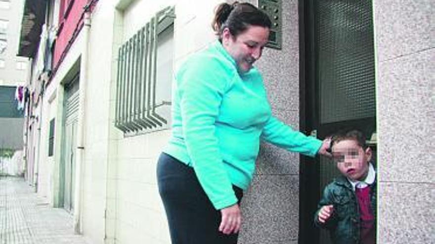 Yolanda Álvarez, con su hijo, a la entrada de su casa.