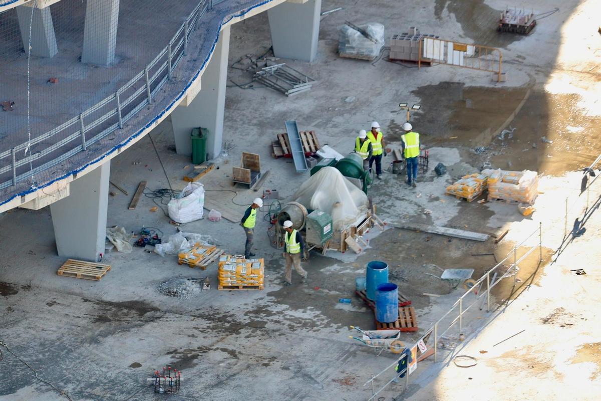 Lo operarios, en una foto de esta mañana, trabajan en uno de los anclajes de la futura cubierta.