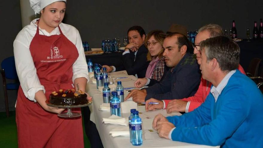 Una de las participantes muestra su tarta al jurado del concurso.