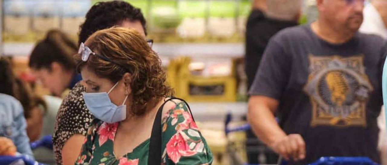 Una mujer realiza su compra en un supermercado en Tenerife.