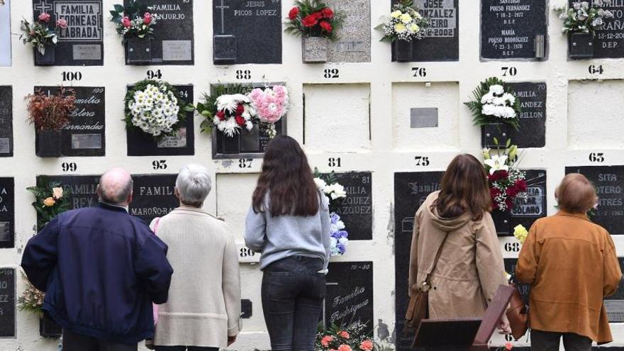 Familiares recuerdan a sus seres queridos fallecidos en una visita al cementerio.