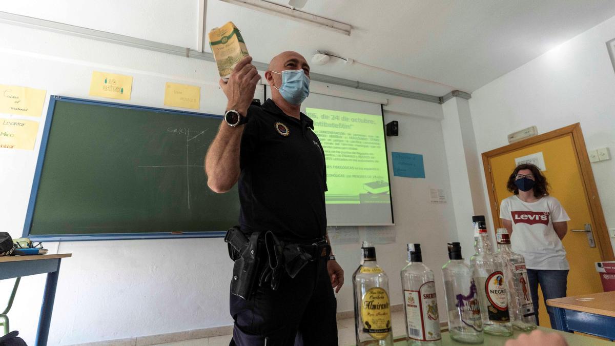 El agente tutor de la Policía Local de Córdoba Jesús Macías muestra unas botellas al alumnado.