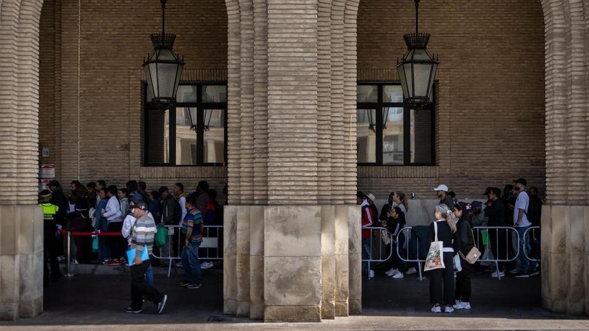 Imagen de archivos de filas en el proceso de regularización de migrantes, en Zaragoza.