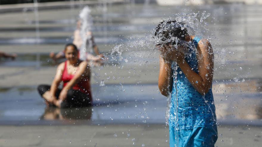 Una mujer se refresca en las fuentes del Parc Central. M.A.Montesinos