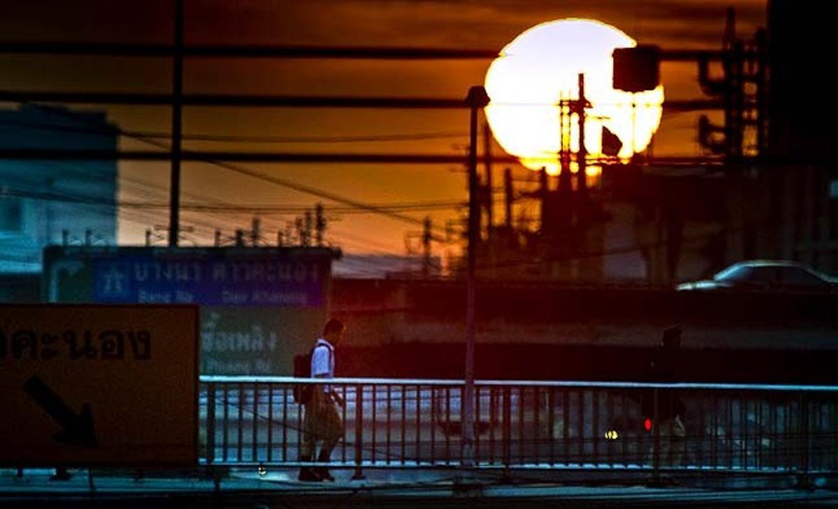 Un vianant de Bangkok (Tailàndia) camina per un pont de vianants.