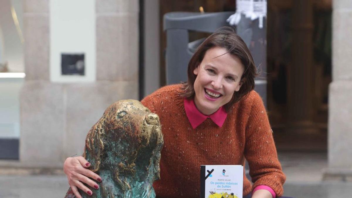 Marta Villaramosa o seu novo libro coa estatua docan Ney, na Coruña.