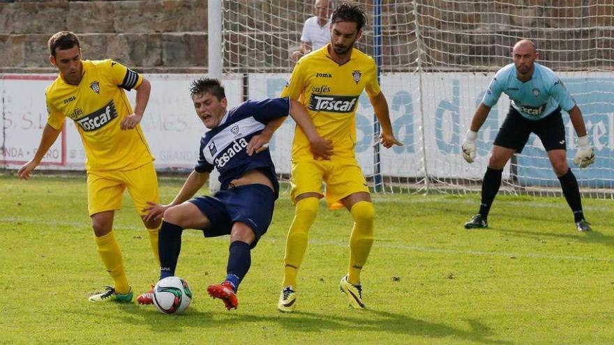 Álvaro cae en el área entre los defensas del Praviano Fran, a la izquierda, y Efrén.