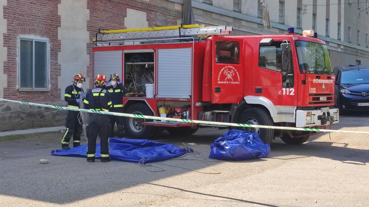 Los bomberos preparando la lona de plástico con la que pudieron sacar el cuerpo del agua.