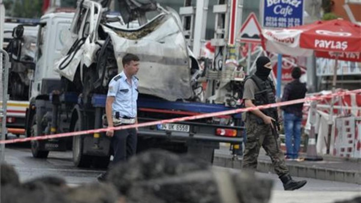 Miembros de los servicios de seguridad turcos inspeccionan la zona donde ha explosionado una bomba en una comisaría de policía en Estambul.