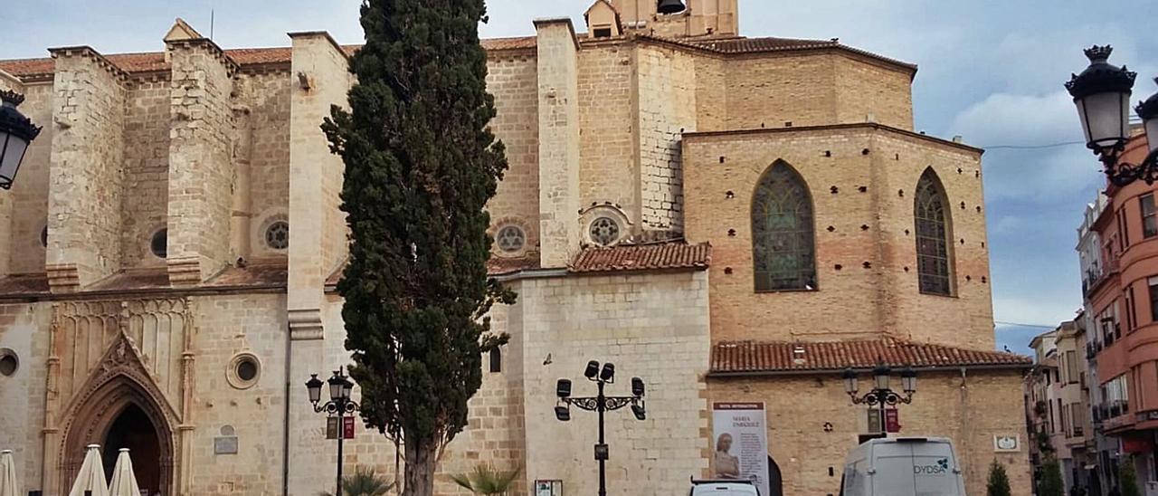 La Colegiata de Gandia y, sobre los dos vehículos, el muro y la ventana que se cubrirían con la publicidad para recaudar dinero. | LEVANTE-EMV