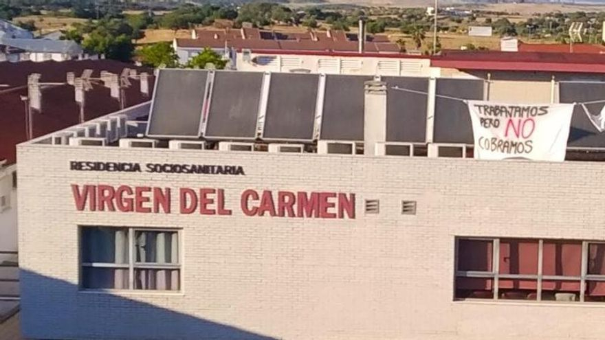 Fachada de la residencia sociosanitaria Virgen del Carmen, con un cartel reivindicativo de los trabajadores por la falta de cobro.