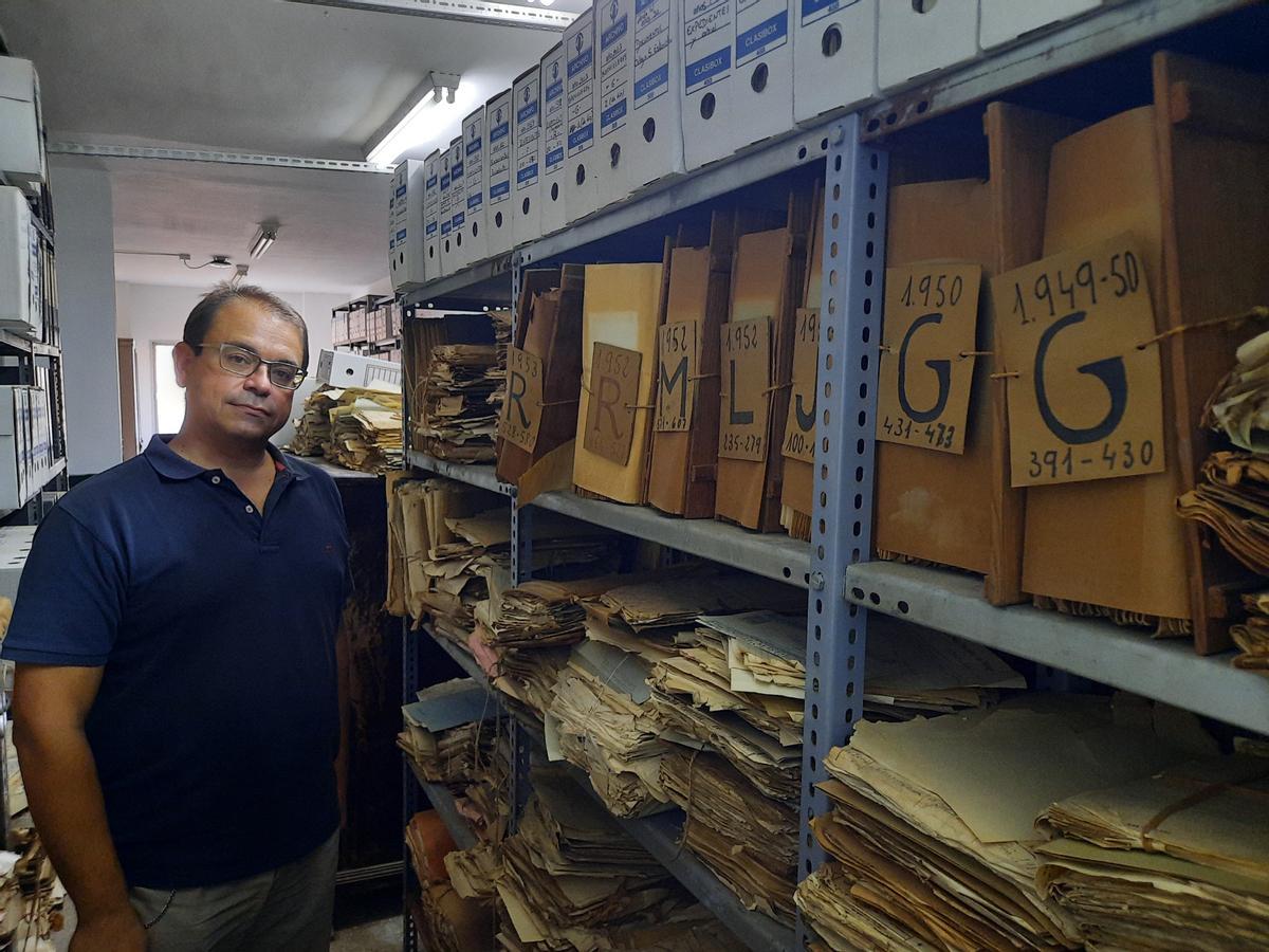 El director del IES Martiricos, junto a unos antiguos expedientes académicos.