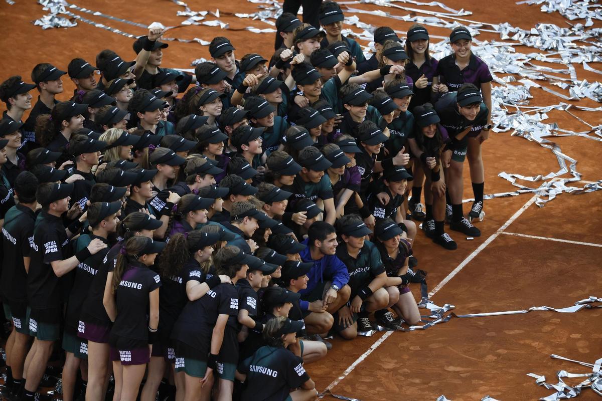 MADRID, 08/05/2022.- El tenista Carlos Alcaraz posa para lo medios gráficos con los recogepelotas que han participado en el Mutua Madrid Open, celebrando su victoria tras derrotar en la final al alemán Alexander Zverev en el encuentro que han disputado hoy Domingo en las instalaciones de la Caja Mágica, en Madrid. EFE/Juanjo Martín.