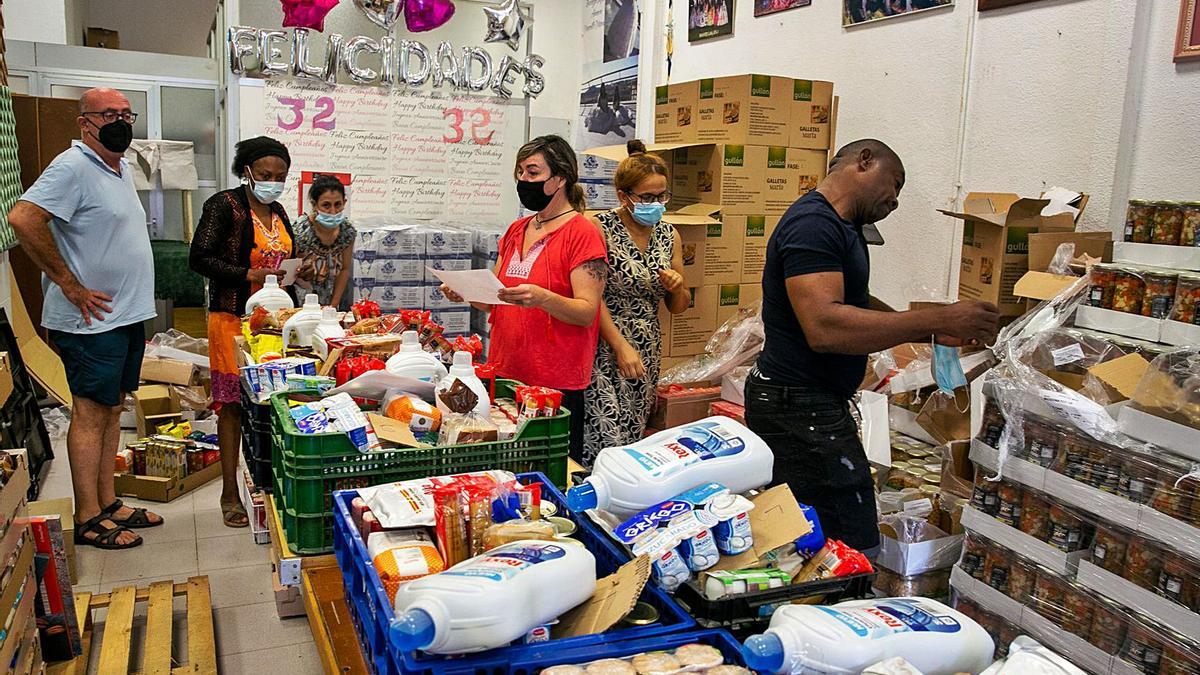 Voluntarios preparan al entrega de alimentos y productos de higiene en el barrio de Colonia Requena.